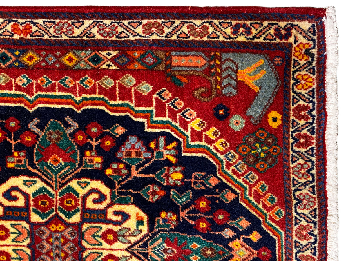 Dettaglio del tappeto: ornamento variopinto nella zona blu scuro con sfondo rosso