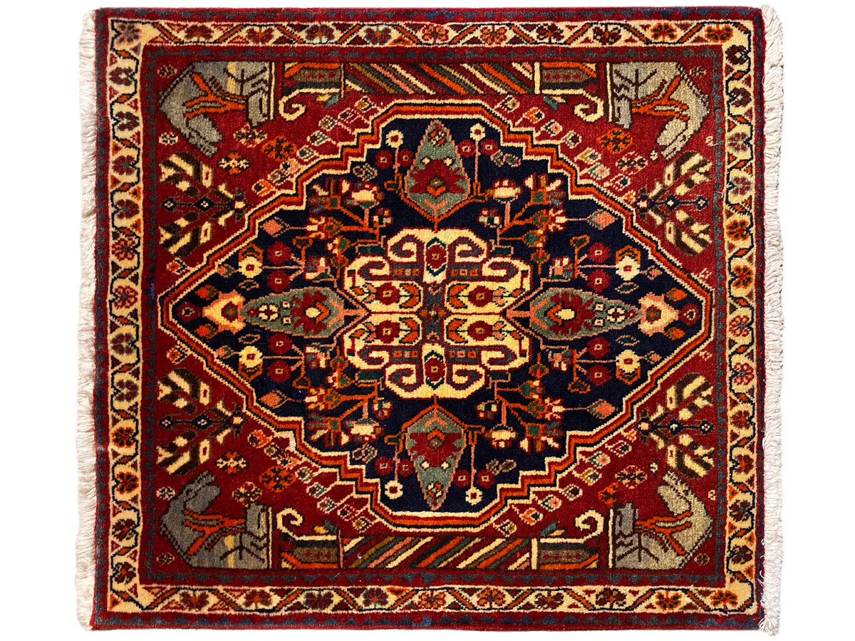 Tappeto 65x59 cm con fondo rosso, ornamenti blu-grigi e motivo simmetrico