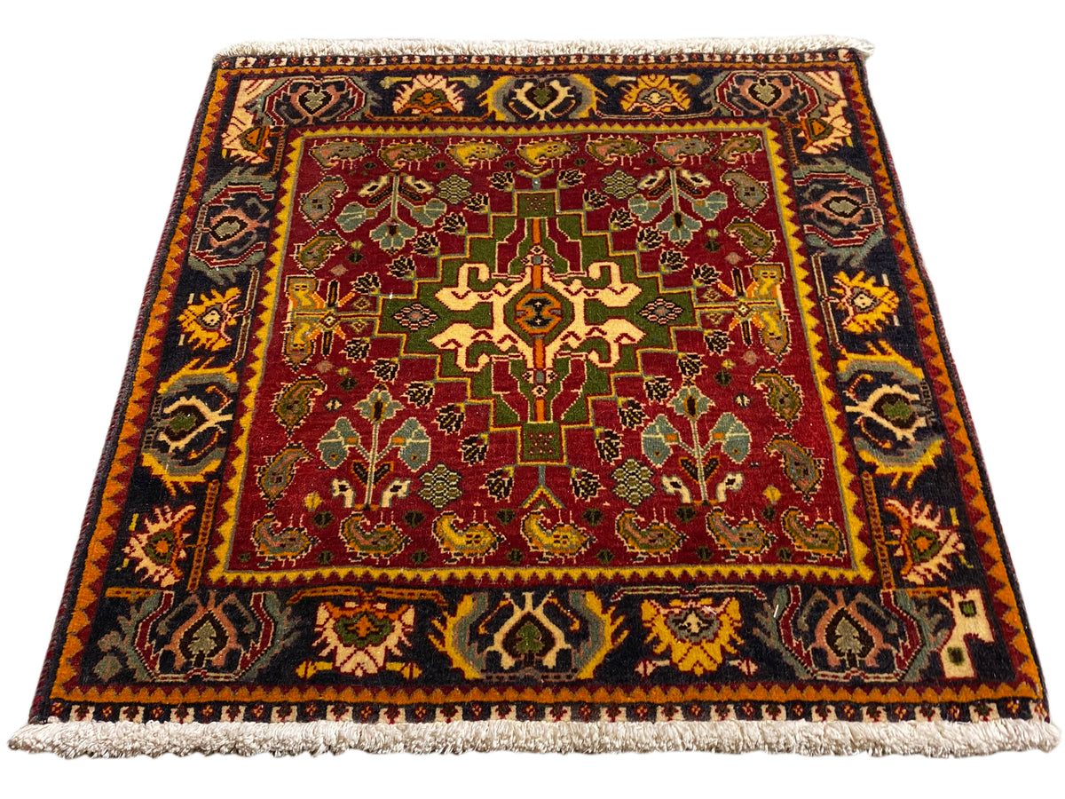 Tappeto con campo interno rosso, ornamenti geometrici e bordo corto con frange