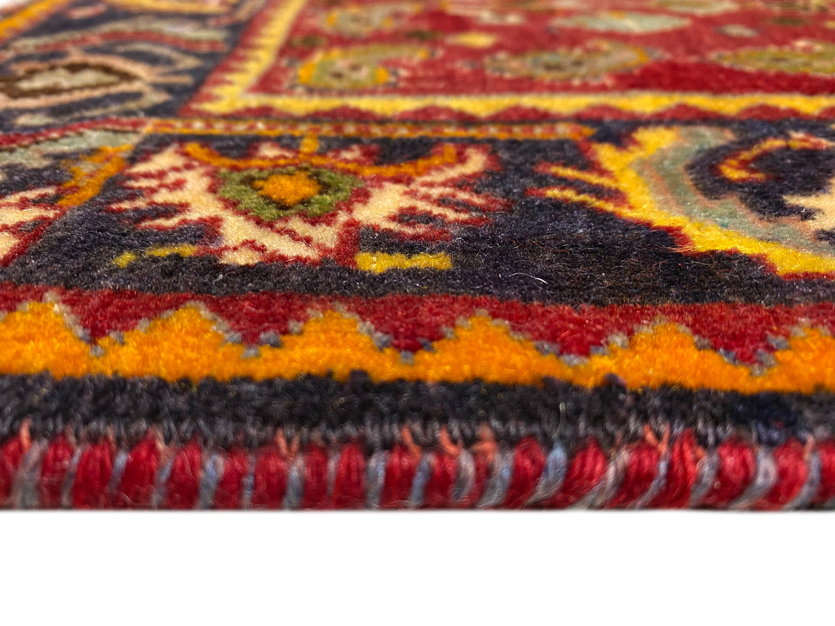 Bordo del tappeto con frange e orlo a motivi in rosso, arancione, blu e nero