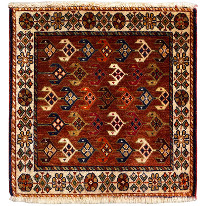 Tappeto Poshti 60x55 cm con motivo geometrico in rosso, marrone, blu e crema