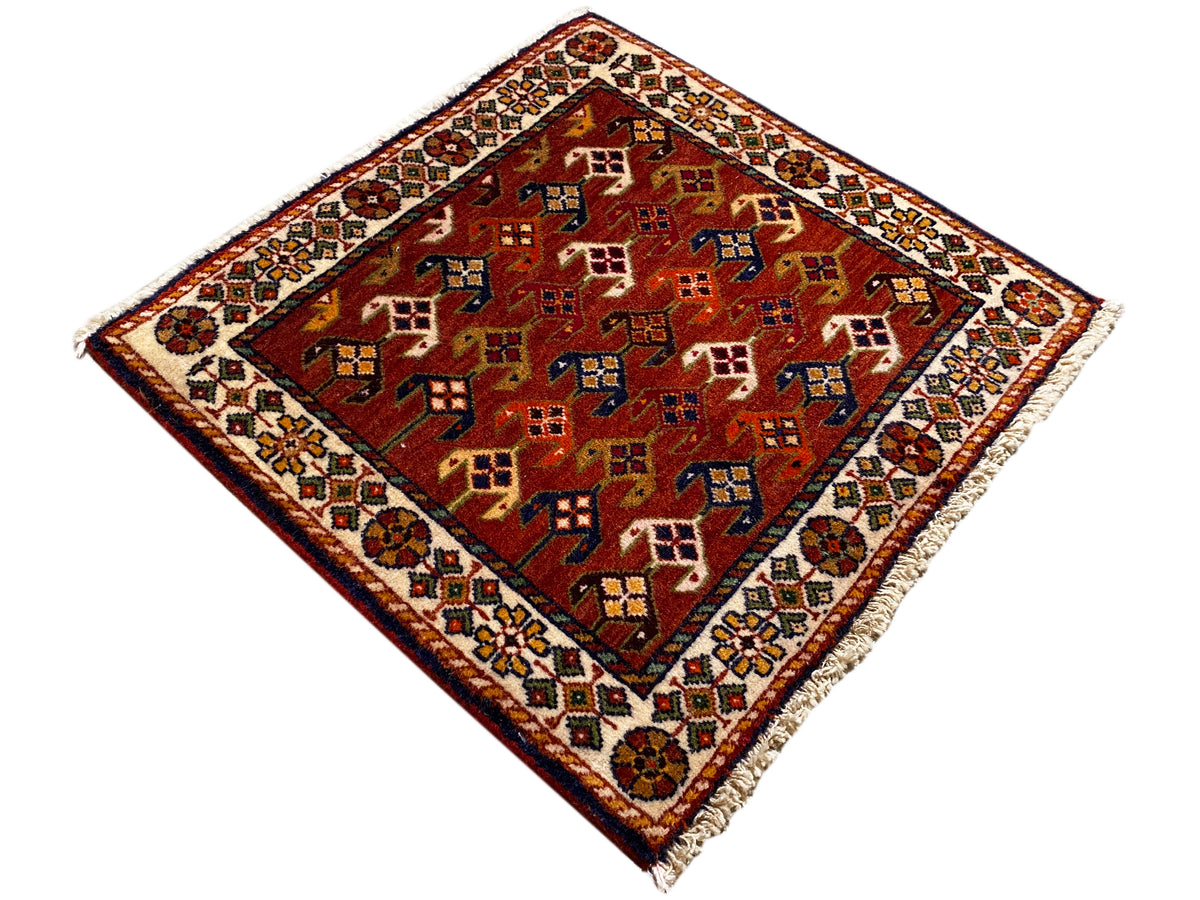 Tappeto 61x61 cm con fondo rosso e motivi geometrici colorati, bordo perimetrale