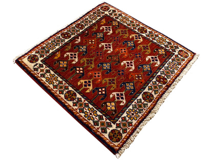 Tappeto 61x61 cm con fondo rosso e motivi geometrici colorati, bordo perimetrale