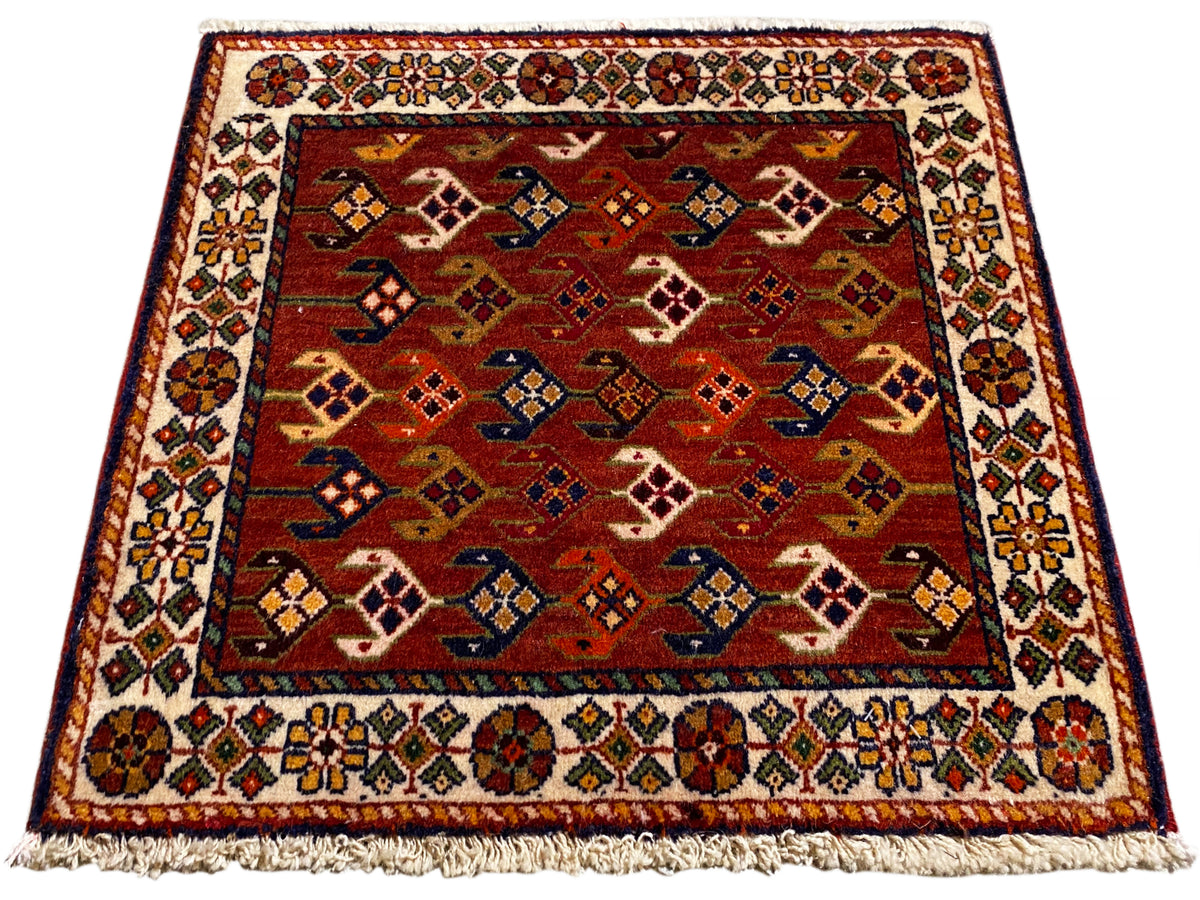 Tappeto con fondo rosso, motivo multicolore e bordura, frange sul bordo
