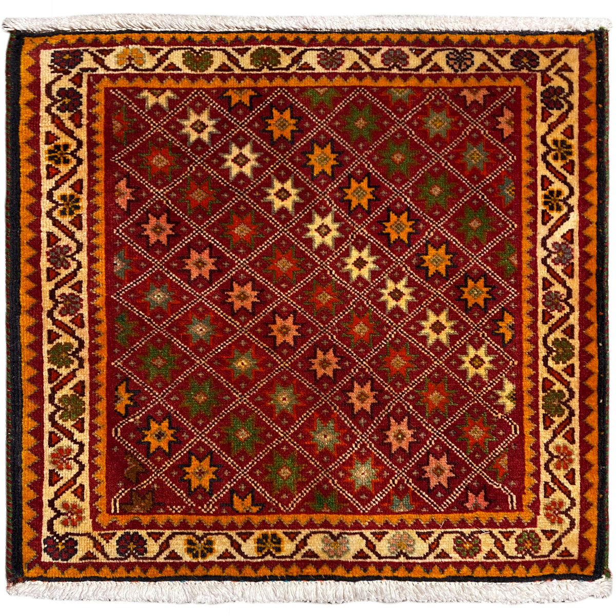 Tappeto persiano, rettangolare, multicolore con motivi ornamentali a stella e bordo sfrangiato.