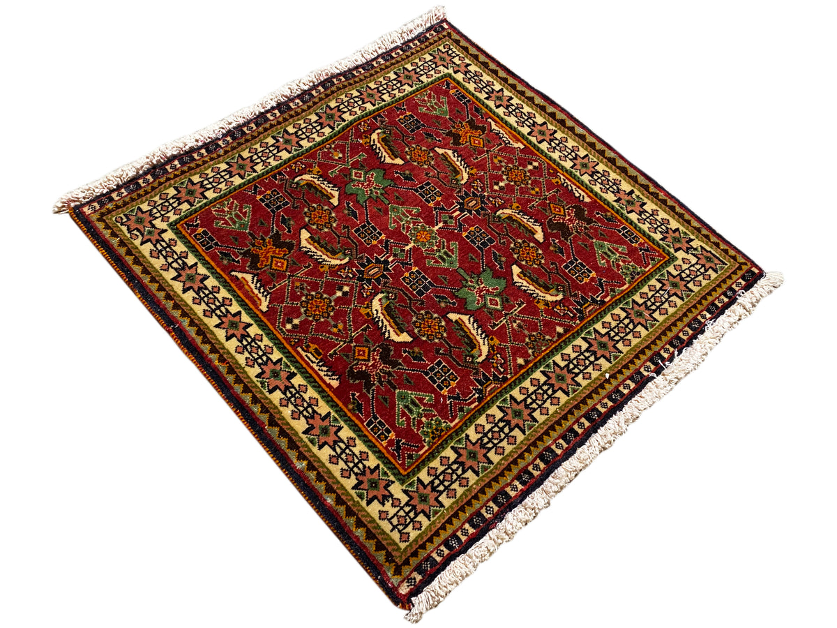 Tappeto Poshti 63x61 cm, vista diagonale: motivo rosso con dettagli verdi, frange.