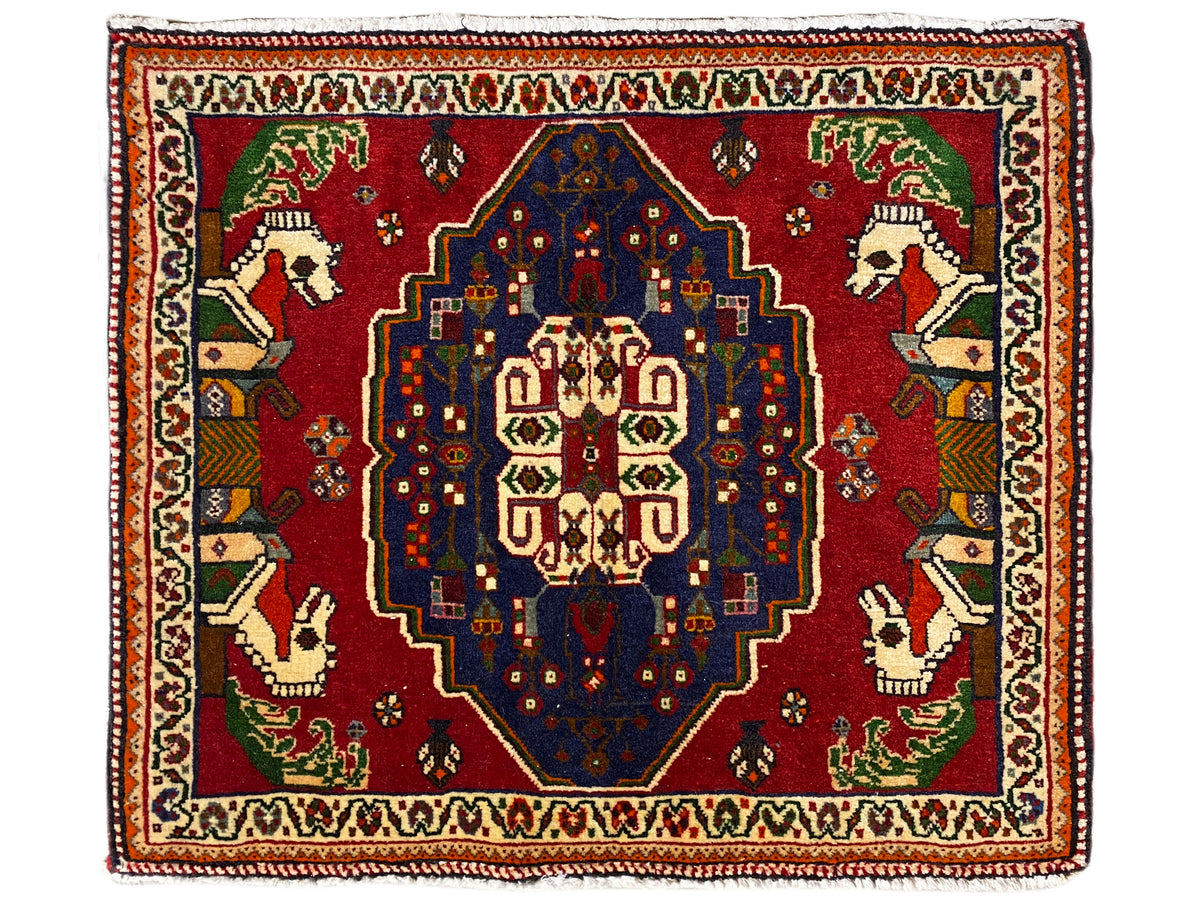Tappeto Poshti con fondo rosso, medaglione centrale blu e bordo decorativo