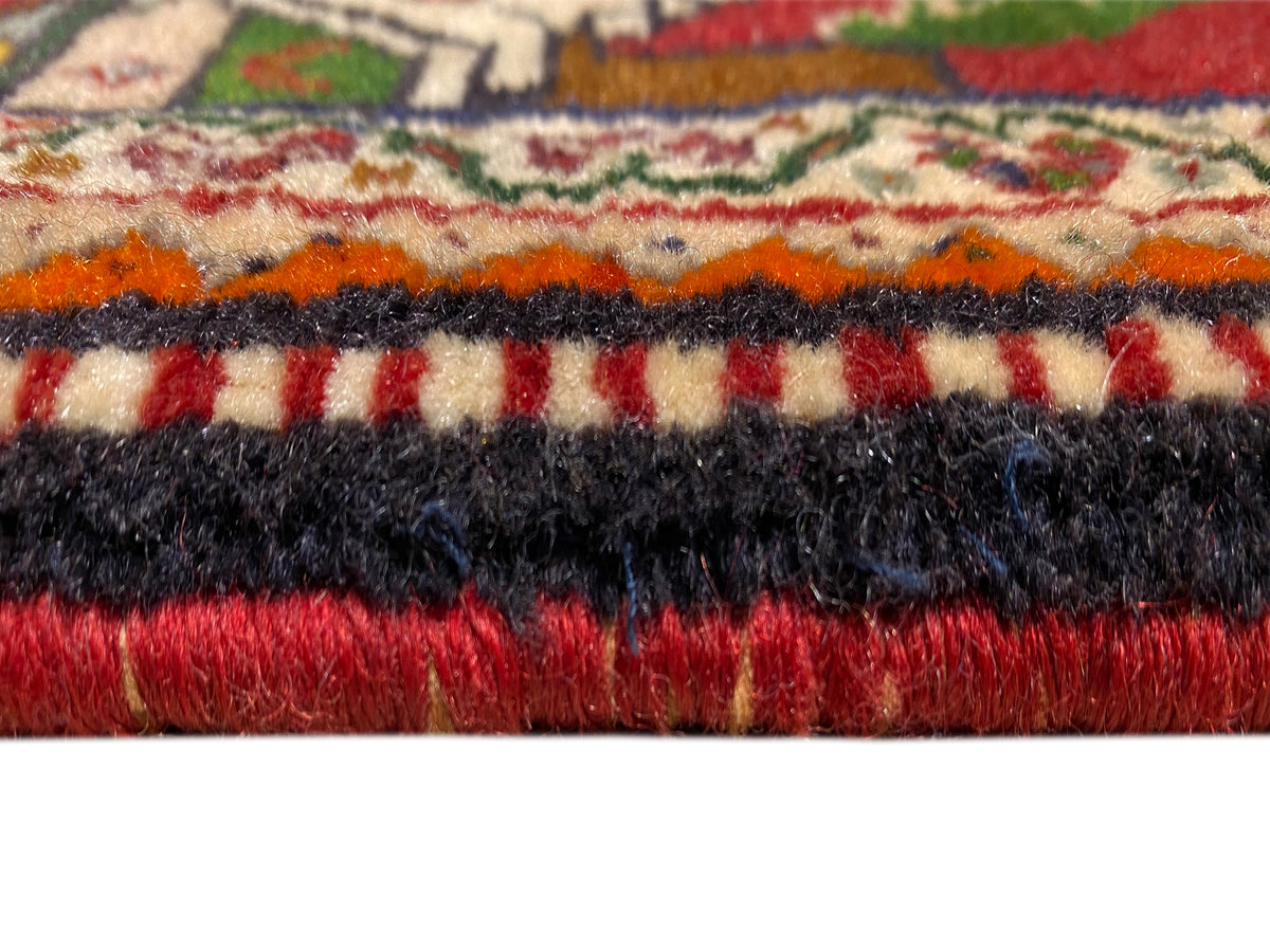 Dettaglio del tappeto Poshti: pelo multicolore con bordo di frange nere e rosse