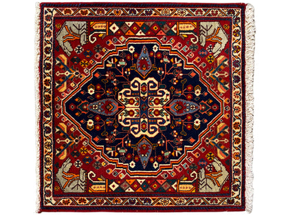 Tappeto quadrato con fondo rosso, stella decorativa blu e bordure ornamentali