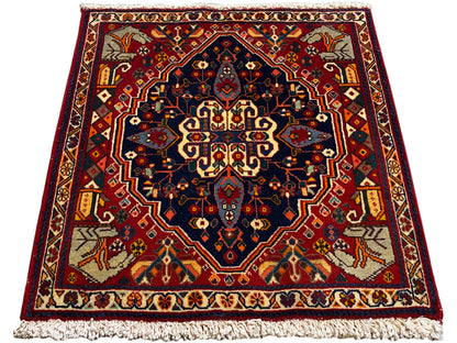 Tappeto rosso e blu scuro con motivo ornamentale centrale, forma rettangolare e frange