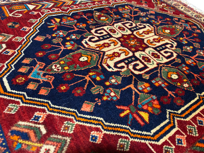 Primo piano di un tappeto 63x60 cm: motivo floreale colorato su sfondo blu scuro