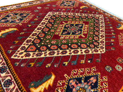 Dettaglio del tappeto Poshti: motivo rosso con medaglione colorato e bordo decorativo perimetrale