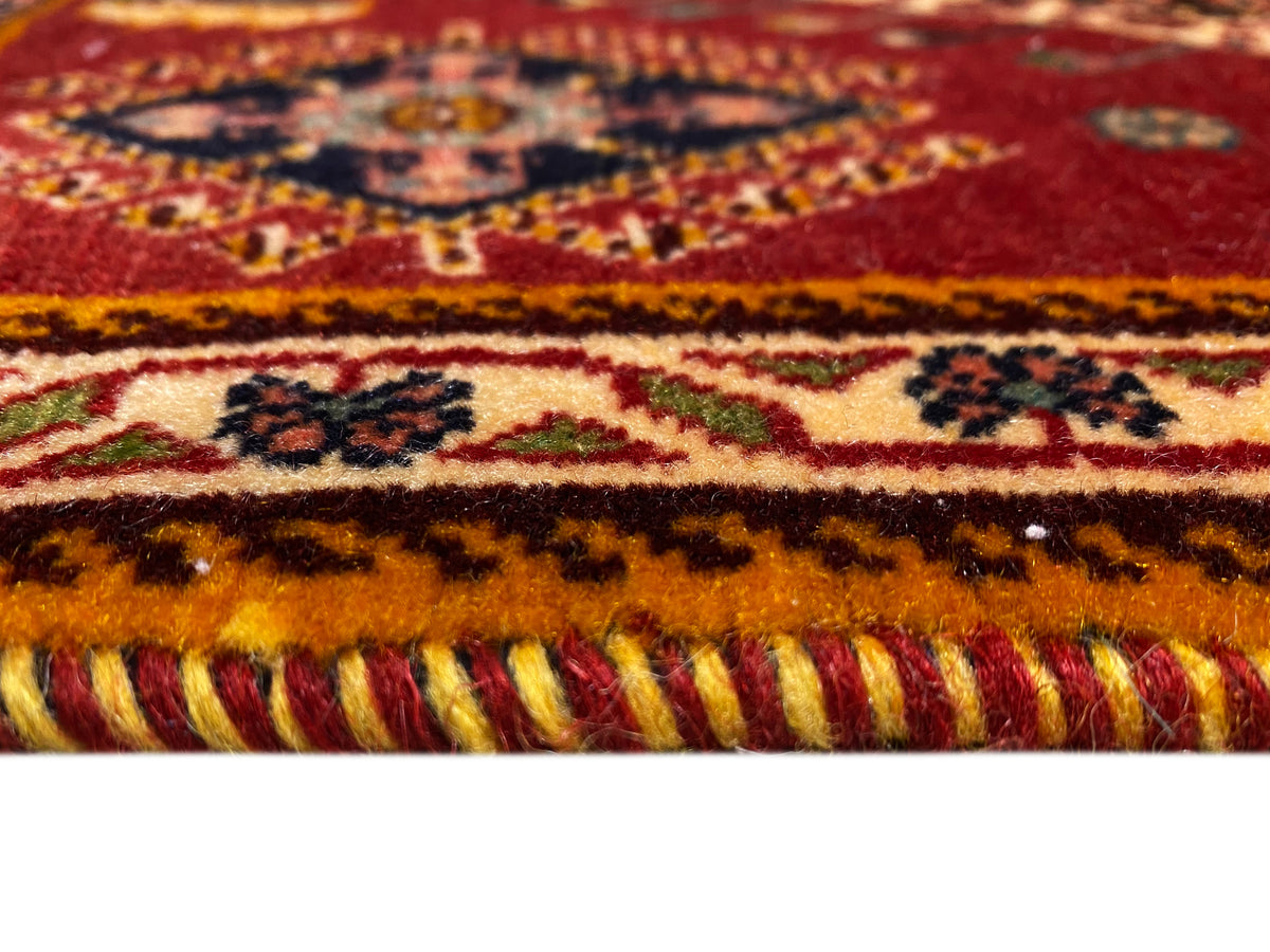 Dettaglio del tappeto Poshti sul bordo: frange e bordure multicolori