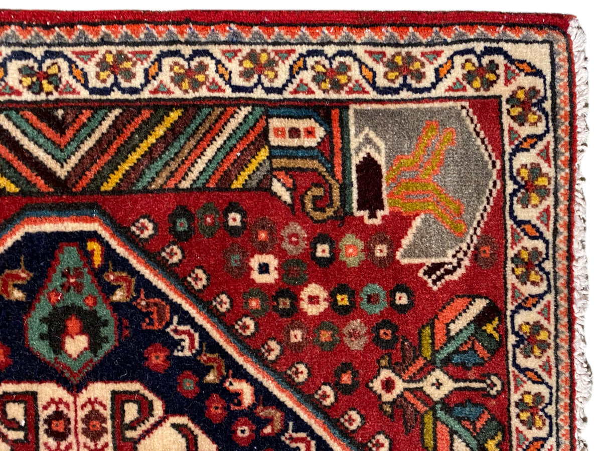 Vista dettagliata: tappeto rosso con motivi ornamentali, bordura multicolore e frange
