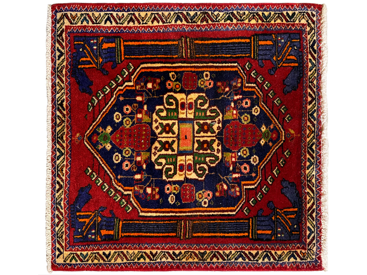 Tappeto Poshti 66x62 cm con medaglione centrale rosso e ornamento angolare blu.