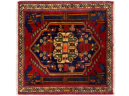 Tappeto Poshti 66x62 cm con medaglione centrale rosso e ornamento angolare blu.