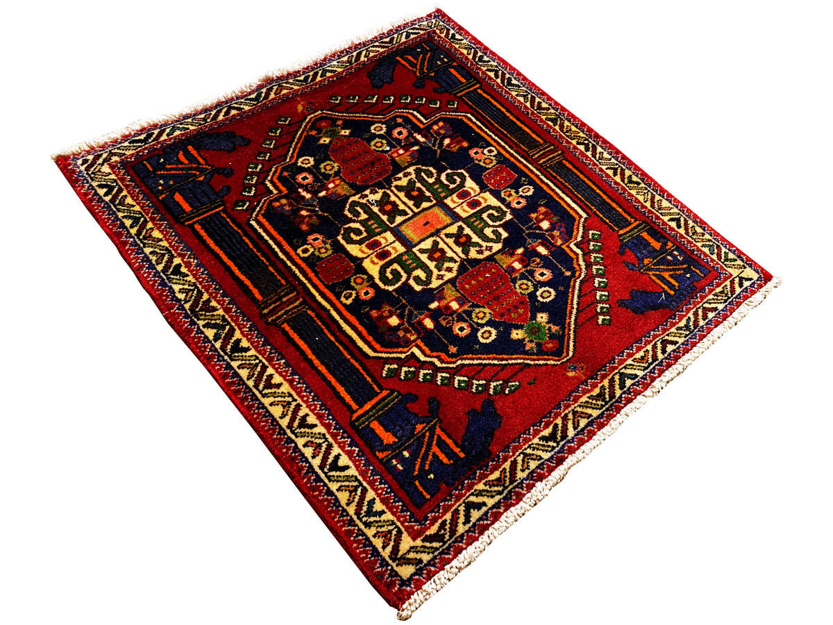 Tappeto Poshti 66x62 cm da aperto: campo interno rosso con motivo geometrico e motivi angolari.