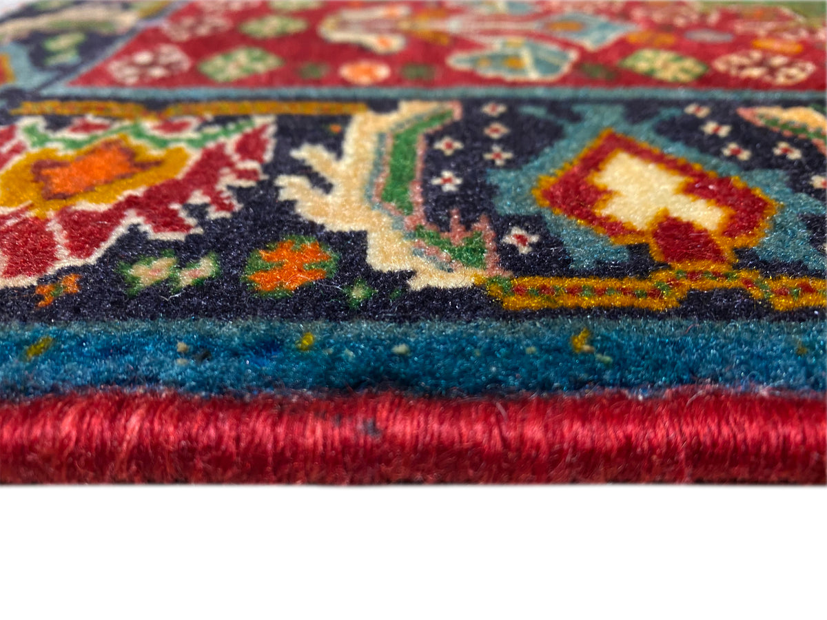 Bordo del tappeto nel dettaglio: motivo ornamentale multicolore e pelo folto con finitura a frange