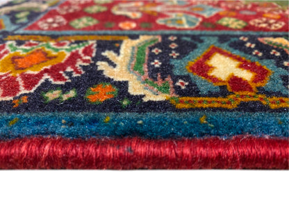 Bordo del tappeto nel dettaglio: motivo ornamentale multicolore e pelo folto con finitura a frange
