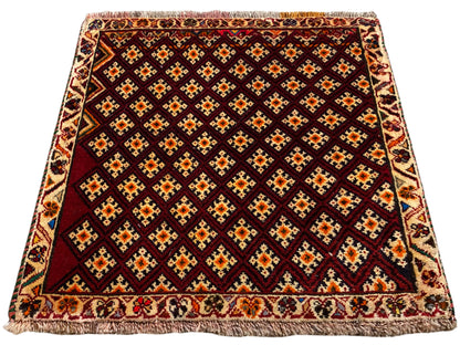 Tappeto Poshti 61x59 cm: tappeto rosso scuro con motivo a rombi e bordo perimetrale con frange