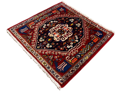 Tappeto con bordo rosso e centro blu scuro, ornamento a forma di stella, frange
