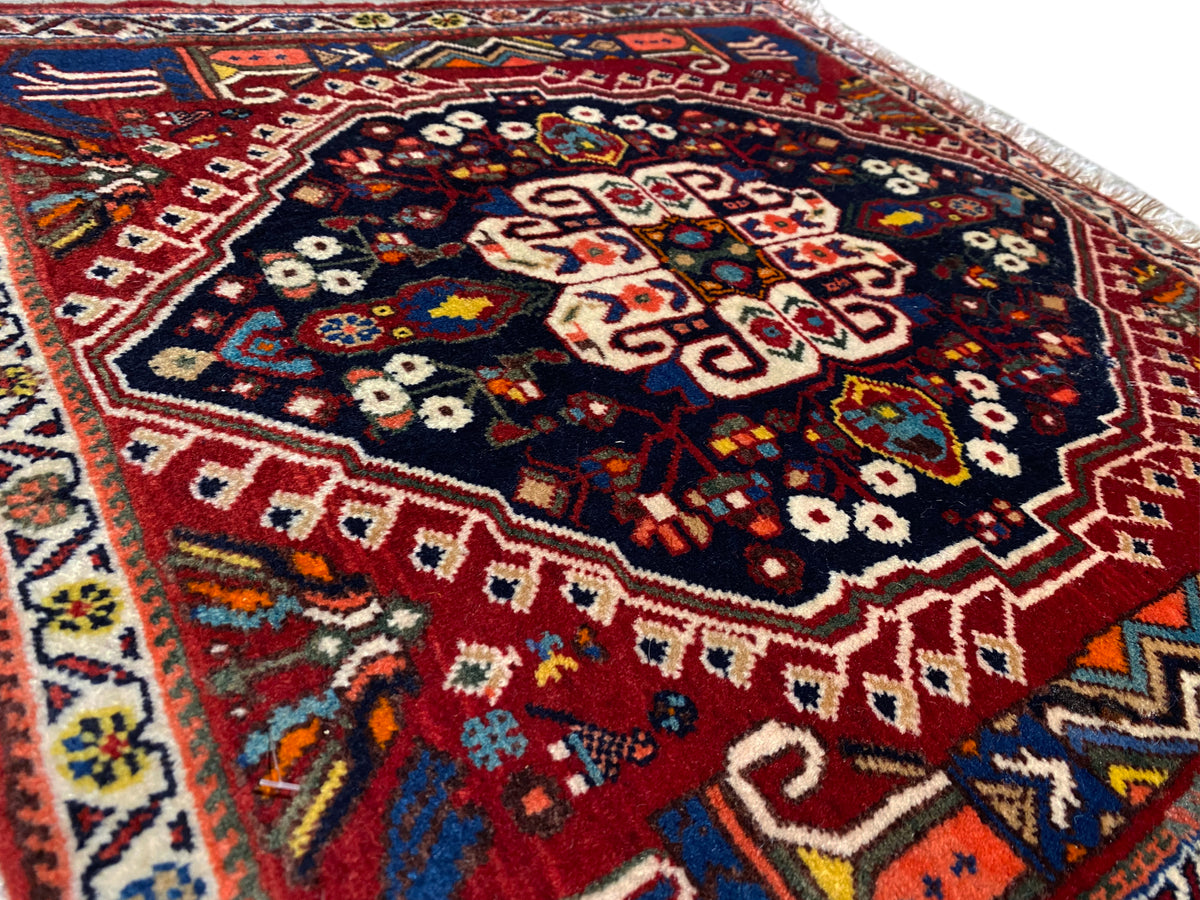 Primo piano del tappeto con motivo geometrico multicolore su sfondo blu scuro