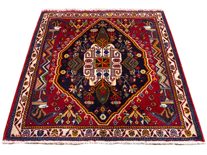 Tappeto Poshti (67×67 cm) in vista obliqua: bordo, centro rosso, blu scuro
