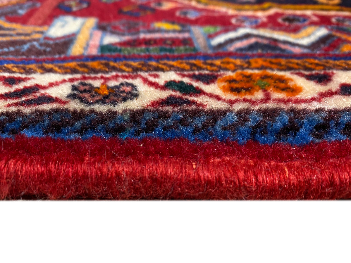 Dettaglio del tappeto con pelo corto e parte inferiore rossa, strisce decorative visibili