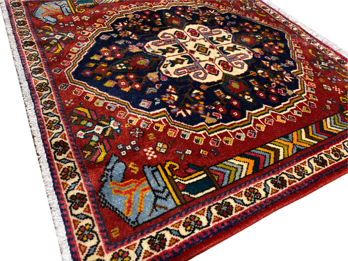Poshti tappeto 65x61 cm vista dettagliata: campo rosso, ornamento blu-nero, bordi a contrasto