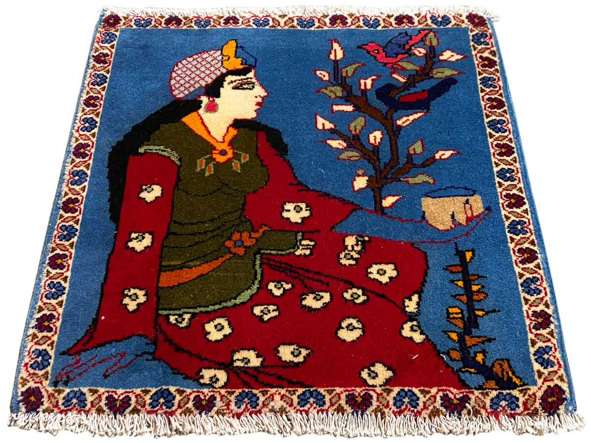 Tappeto Poshti 65x63 cm con motivo fiabesco, superficie blu, parte centrale rossa e frange
