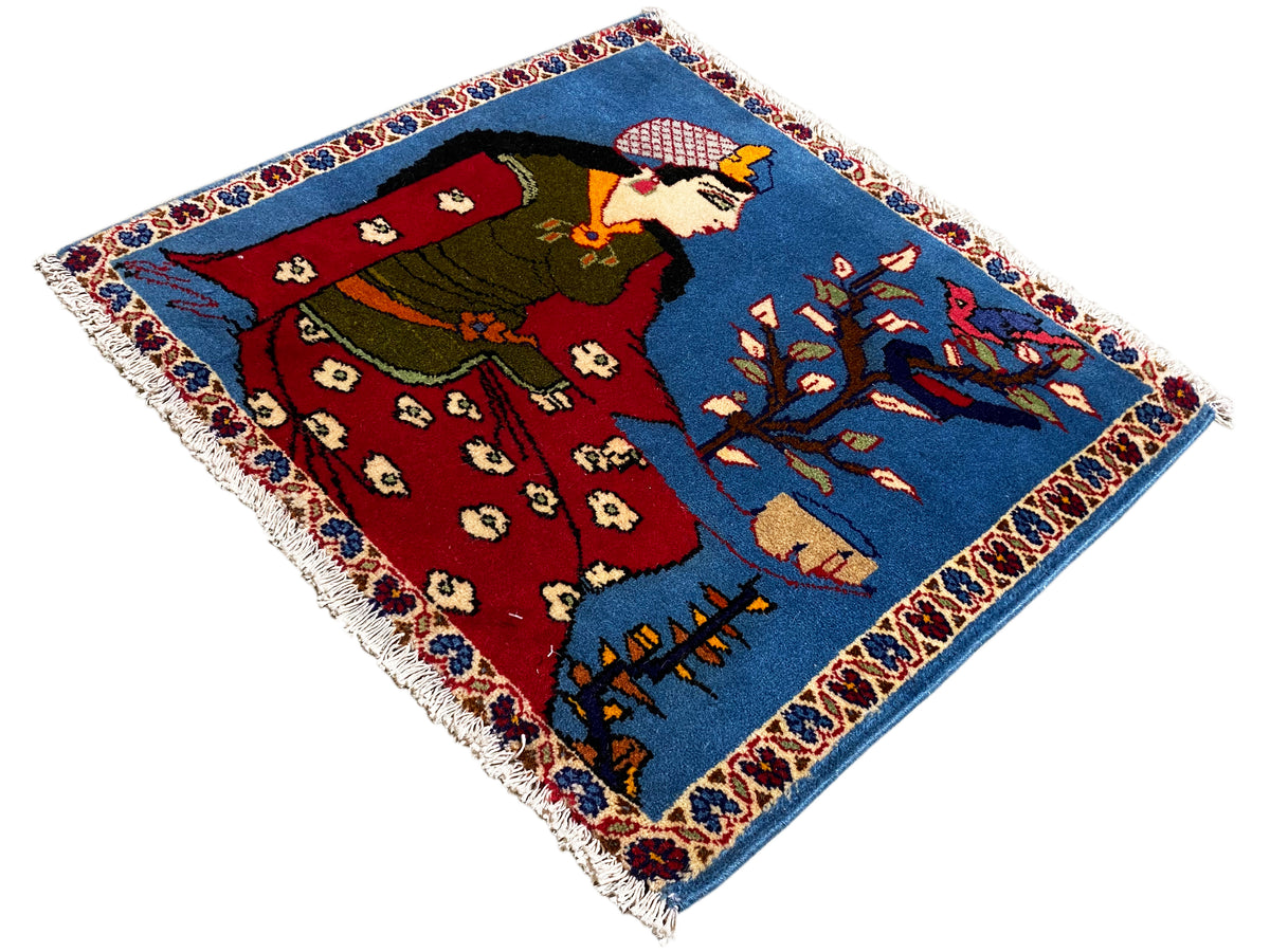 Tappeto Poshti 65x63 cm visto di scorcio, figura, veste rossa e ornamenti blu