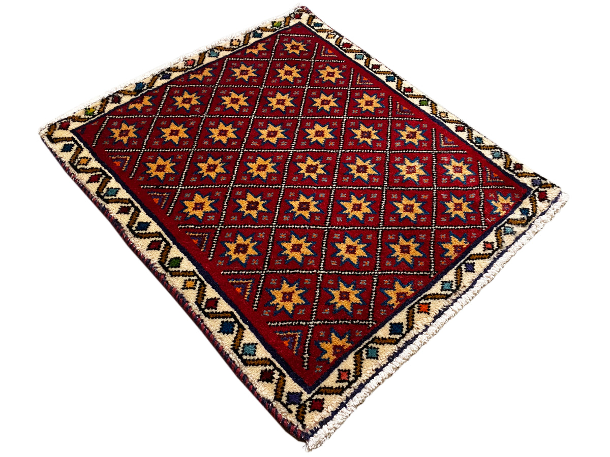 Tappeto quadrato srotolato con motivo geometrico rosso e bordo colorato