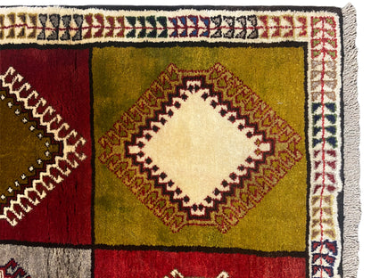 Detail vom Orientteppich: Rautenfeld in Rot, Grün und Gelb mit heller Zierkante