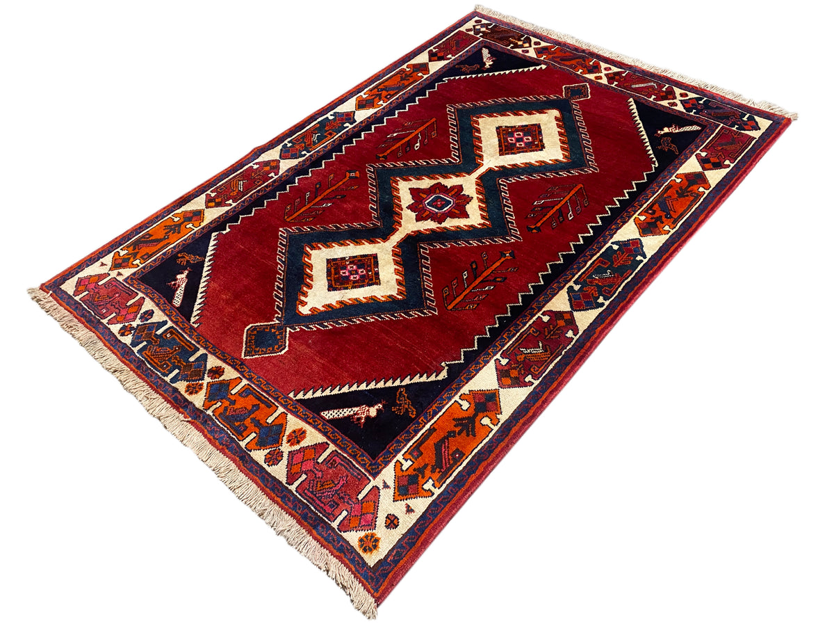 Shiraz Qashqai-Teppich mit rotem Mittelbereich, dunkelblauen Feldern und Fransen